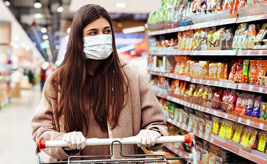 woman with face mask pushing grocery cart