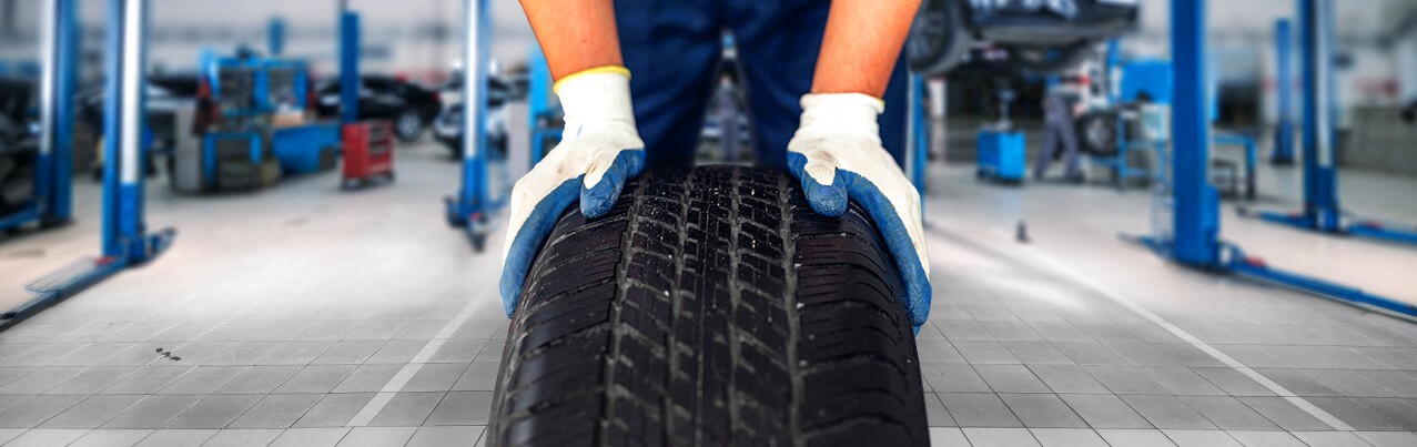 man with gloves holding a tyre