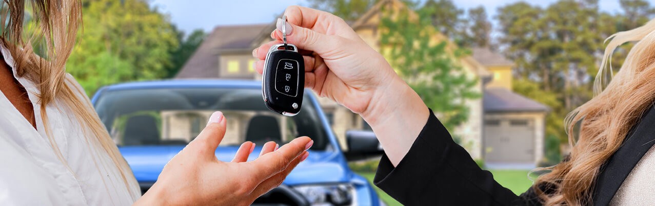 car dealer handing keys to owner