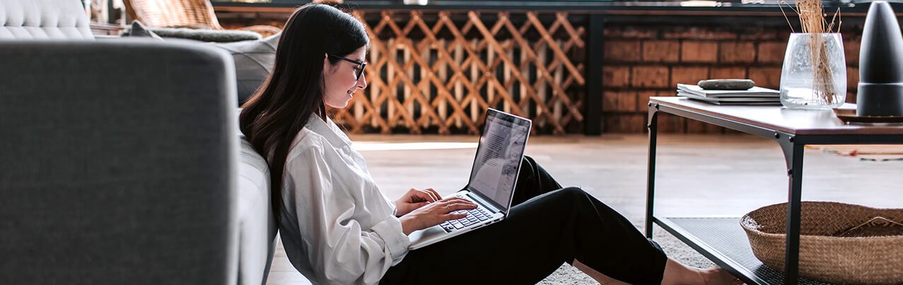woman with laptop sitting on the floor