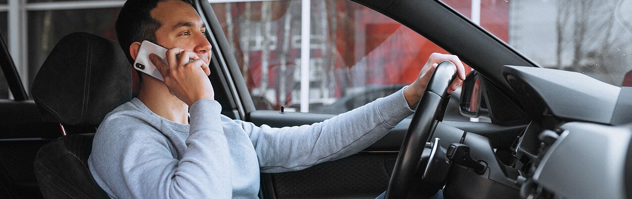 man driving while on phone